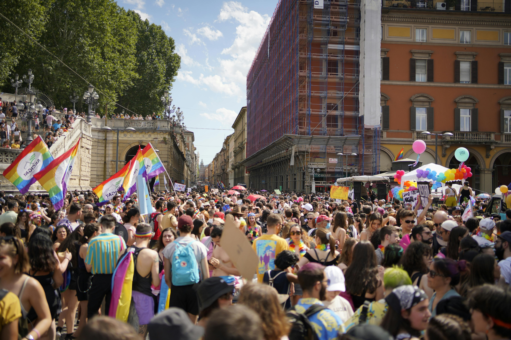 Gruppo di persone che ballano e festeggiano in strada durante una parata del Pride.